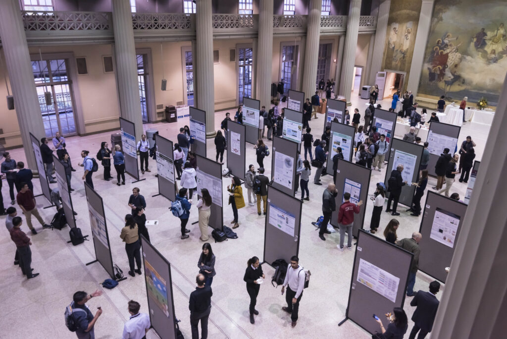 overhead view of a large hall and people walking around standing poster displays