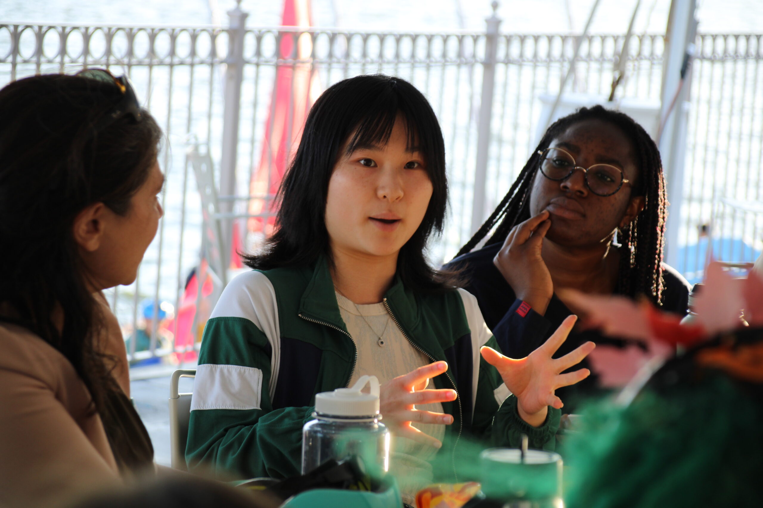 A student speaks while two others look on